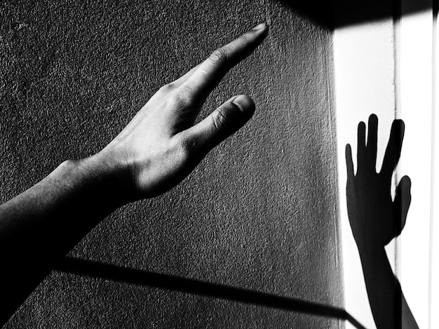 Vue rapprochée de la main par le mur avec l'ombre