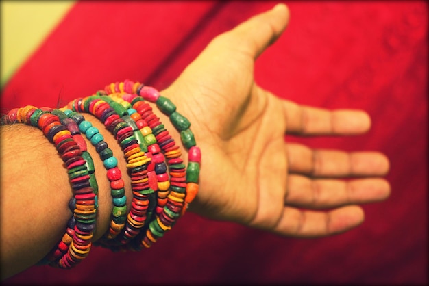 Photo vue rapprochée d'une main portant des bracelets colorés