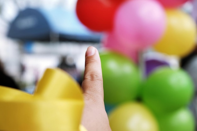 Photo vue rapprochée d'une main tenant des ballons multicolores