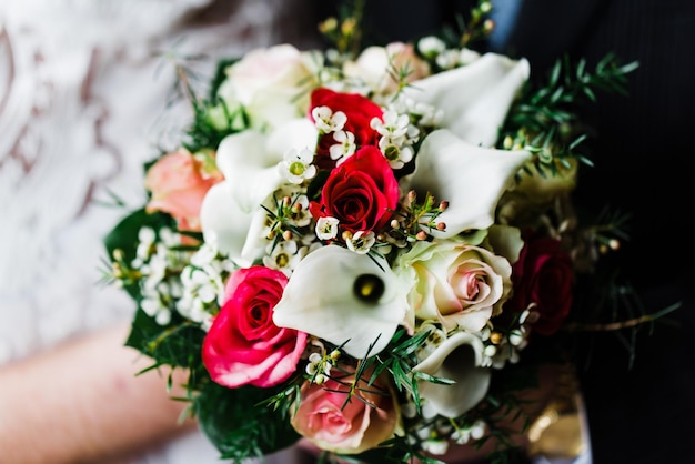 Vue rapprochée d'une main tenant un bouquet de roses