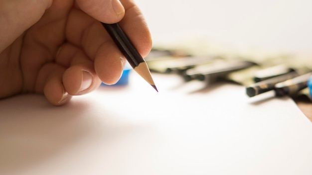 Vue rapprochée d'une main tenant un crayon