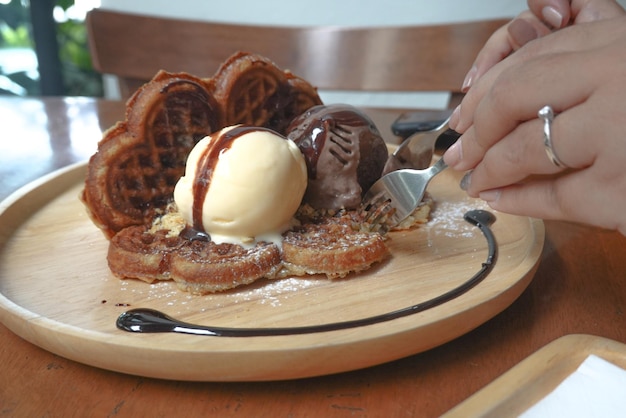 Vue rapprochée d'une main tenant de la crème glacée sur la table