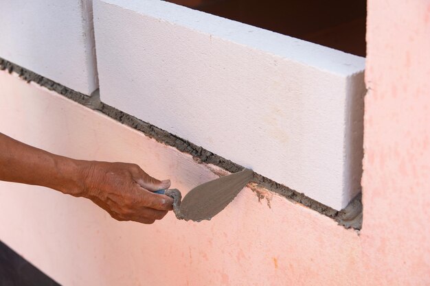 Photo vue rapprochée d'une main tenant du papier contre le mur