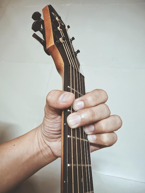 Photo vue rapprochée d'une main tenant une guitare