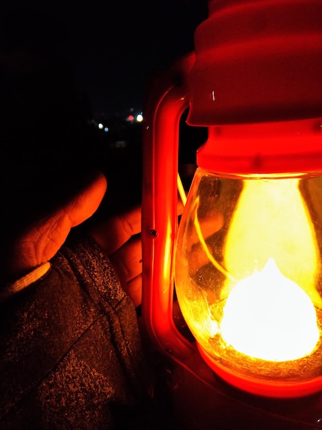 Photo vue rapprochée d'une main tenant une lanterne la nuit