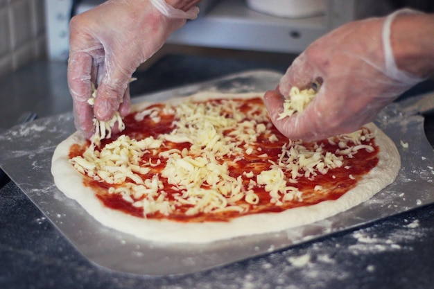 Photo vue rapprochée d'une main tenant une pizza