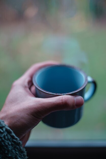 Photo vue rapprochée d'une main tenant une tasse de thé