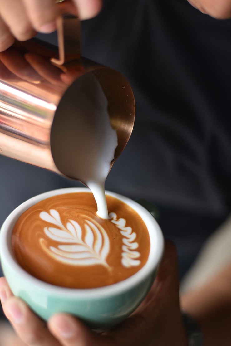 Photo vue rapprochée de la main versant du café dans la tasse