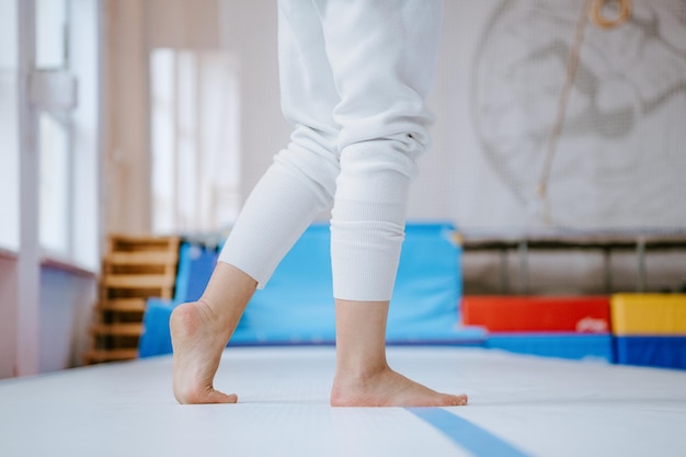 Photo vue rapprochée des mains féminines touchant le tapis femme pratiquant le yoga à la maison concept uttanasana tête aux genoux