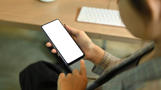 Vue rapprochée des mains de femme au travail tenant un téléphone mobile Affichage vide pour votre texte publicitaire