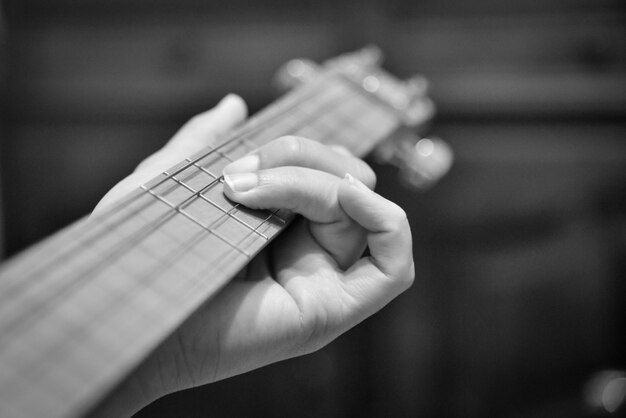 Photo vue rapprochée des mains jouant de la guitare