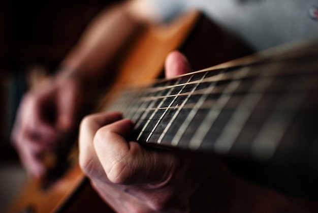 Vue rapprochée des mains jouant de la guitare
