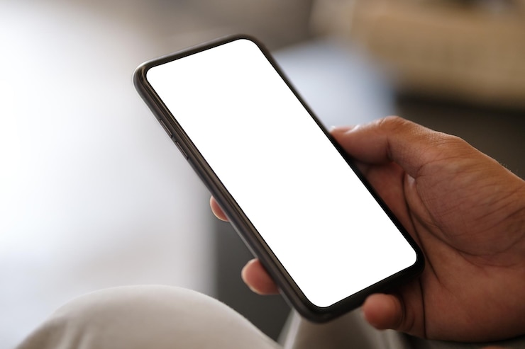 Photo vue rapprochée des mains tenant un smartphone avec écran vide et côté gauche avec un espace vide pour votre publicité ou message texte