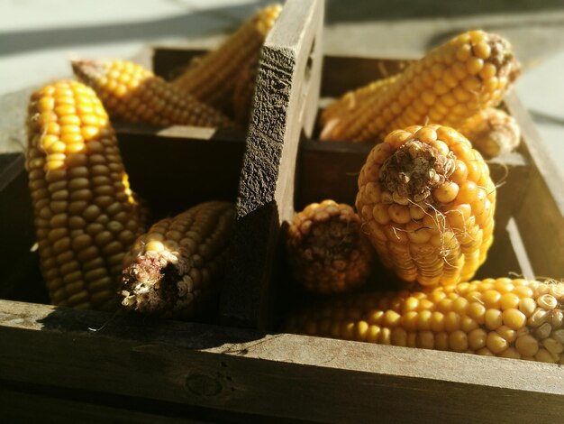 Vue rapprochée des maïs dans un récipient en bois sur table