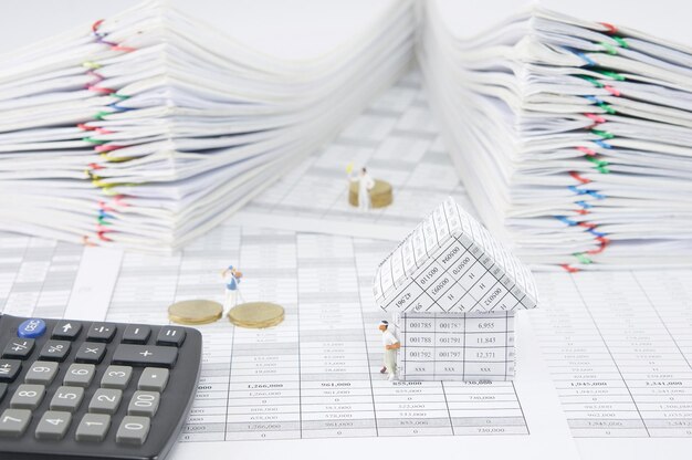 Photo vue rapprochée d'une maison modèle avec une calculatrice et des figurines sur des documents financiers