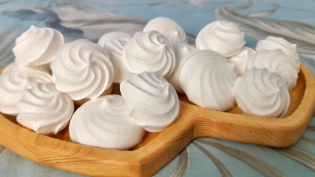 Photo vue rapprochée d'une meringue blanche fraîchement cuite posée sur une assiette en bois