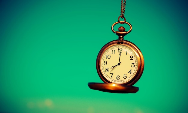 Vue rapprochée d'une montre de poche sur un fond turquoise