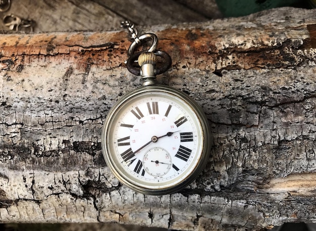 Photo vue rapprochée d'une montre de poche vintage sur surface en bois