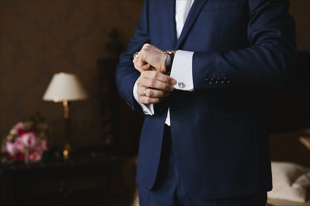 Vue rapprochée des montres de luxe sur la main d'un homme d'affaires dans un costume et dans une chemise avec des boutons de manchette.