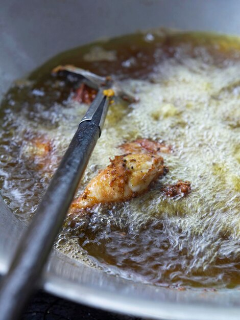 Photo vue rapprochée d'une nourriture frite dans de l'huile de cuisson