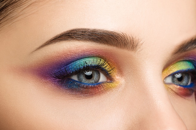 Vue rapprochée de l'oeil féminin bleu avec un beau maquillage créatif moderne