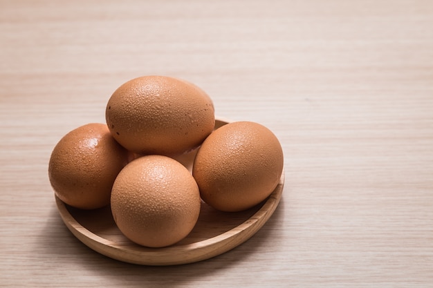 Vue rapprochée des oeufs de poule sur fond de table en bois