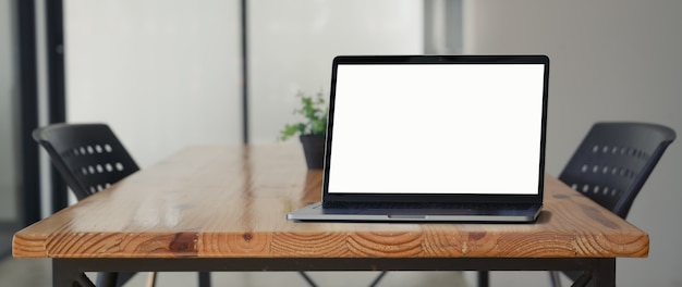 Vue rapprochée d'un ordinateur portable sur un bureau en bois dans un espace de coworking