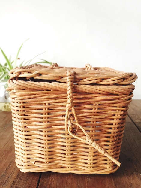 Vue rapprochée d'un panier en osier sur la table contre le mur