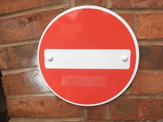 Photo vue rapprochée d'un panneau d'arrêt sur un mur de briques rouges