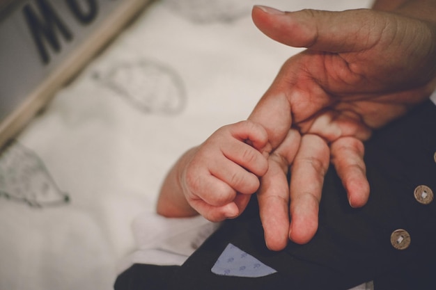 Photo vue rapprochée d'une personne tenant la main d'un bébé