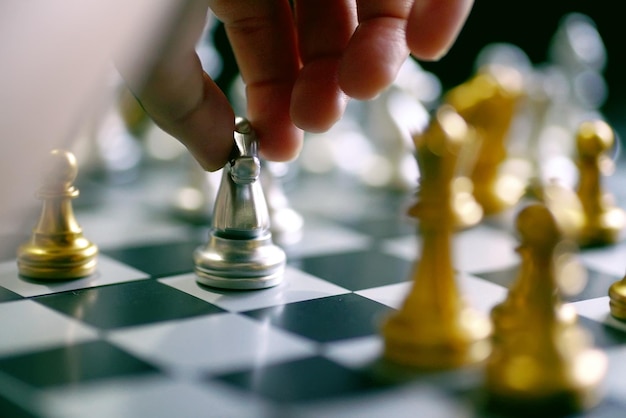 Photo vue rapprochée d'une personne tenant une pièce d'échecs à bord