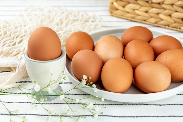 Vue rapprochée de la plaque d'argile pleine de nombreux œufs de poule brun entiers crus pour la cuisson des aliments frais faits maison.