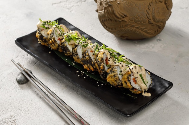 Photo vue rapprochée de la plaque avec des rouleaux de tempura sur fond gris