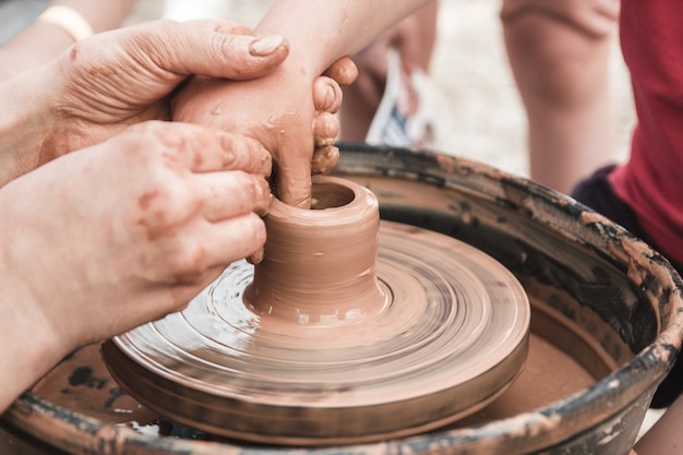 Une vue rapprochée sur le processus de production de céramique sur le tour de potier avec des enfants Artisanat d'argile avec des enfants