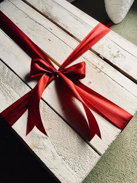 Photo vue rapprochée d'un récipient de cadeau en bois attaché à un ruban sur un tapis