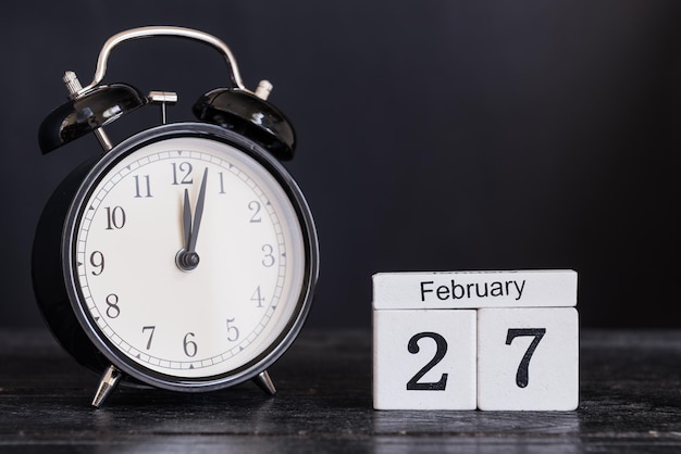 Photo vue rapprochée d'un réveil avec un calendrier sur la table