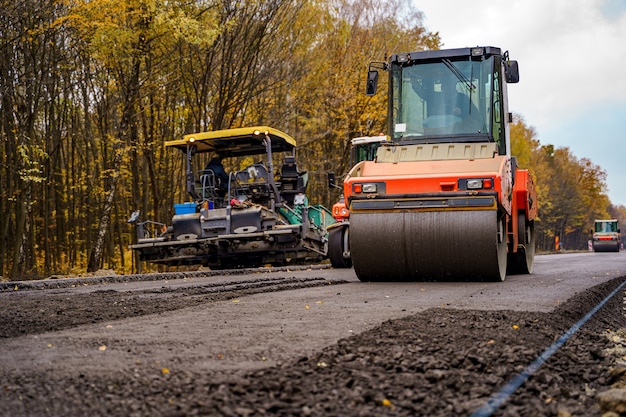 Vue rapprochée sur le rouleau compresseur travaillant sur le nouveau chantier de construction routière. Mise au point sélective. Fermer