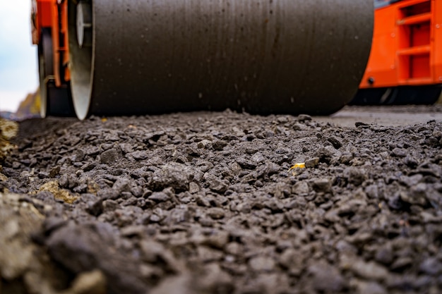 Vue rapprochée sur le rouleau compresseur travaillant sur le nouveau chantier de construction routière. Mise au point sélective. Fermer