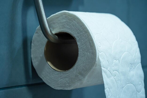 Photo vue rapprochée d'un rouleau de papier toilette suspendu à un support sur un mur de salle de bain