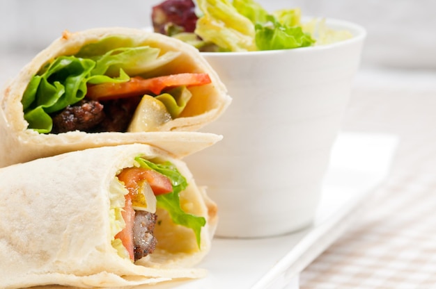 Vue rapprochée d'un sandwich enveloppé servi dans une assiette