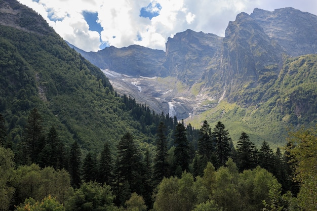 Vue rapprochée des scènes de montagnes et de la cascade lointaine dans le parc national Dombai, Caucase, Russie, Europe. Paysage d'été, temps ensoleillé et journée ensoleillée