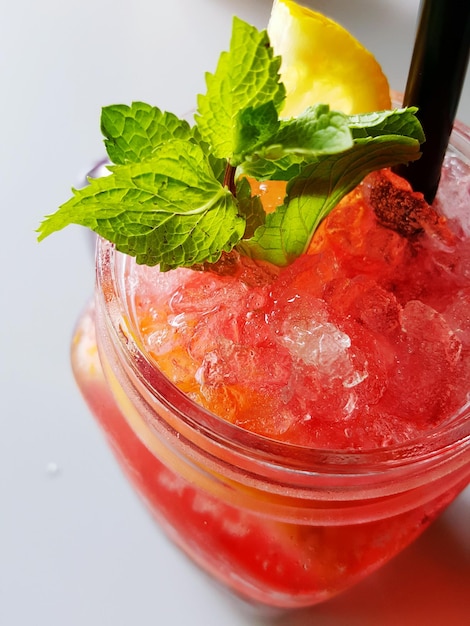 Vue rapprochée d'un smoothie à la fraise dans un pot de maçon sur la table