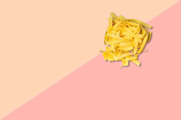 Vue rapprochée des spaghettis italiens crus isolés sur un fond rose