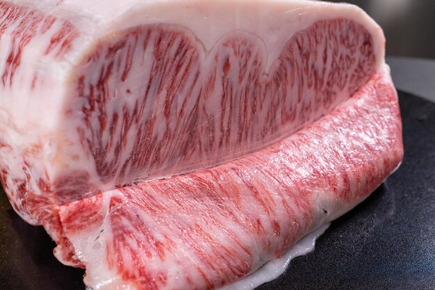 Vue rapprochée d'un steak de wagyu cru sur une planche sur la table de la cuisine