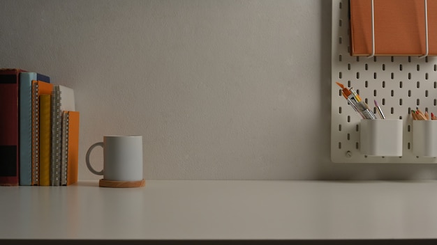 Vue rapprochée de la table d'étude avec des livres de papeterie et de l'espace de copie dans la salle de bureau à domicile