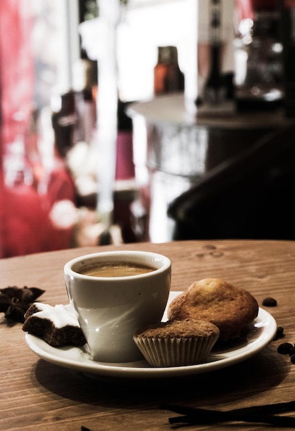 Vue rapprochée d'une tasse de café avec des cupcakes sur la table