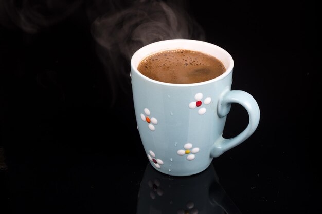 Photo vue rapprochée d'une tasse de café sur un fond noir