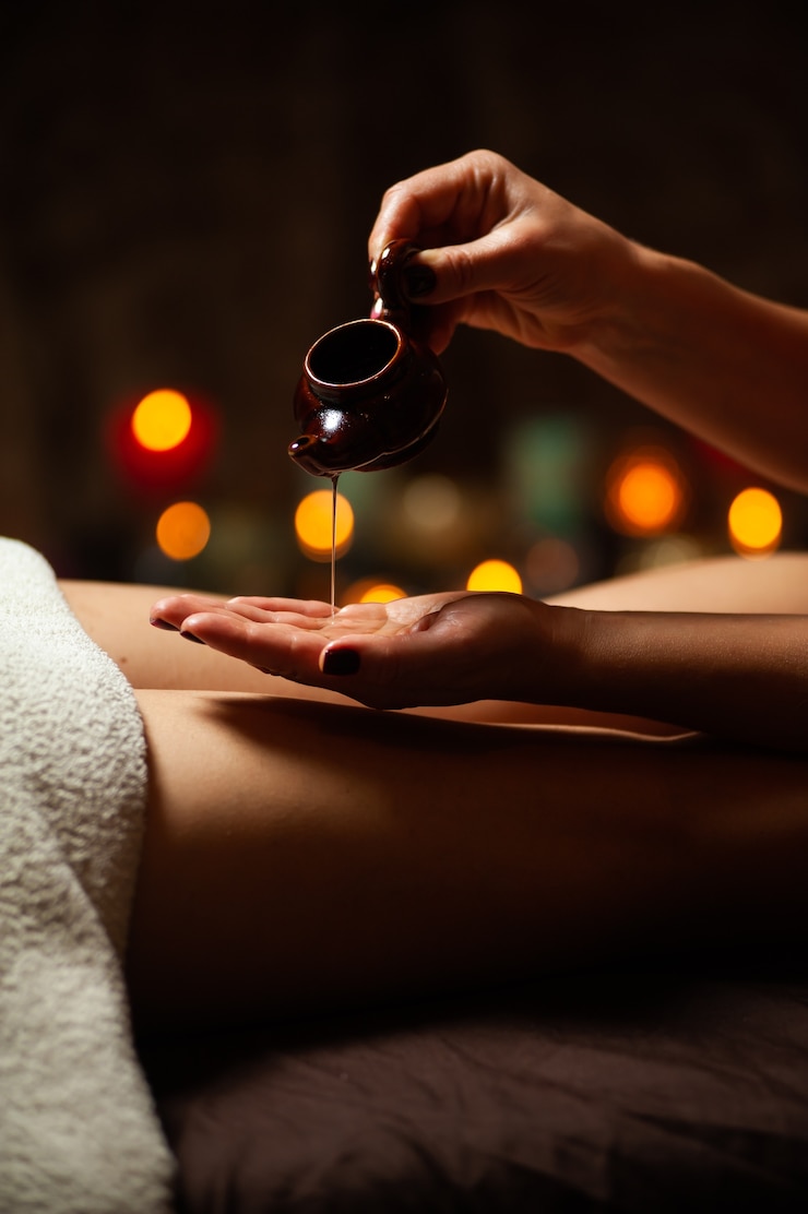 Photo vue rapprochée d'un thérapeute versant de l'huile pour un traitement de spa
