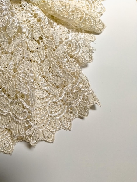 Vue rapprochée d'un tissu de dentelle florale sur fond blanc