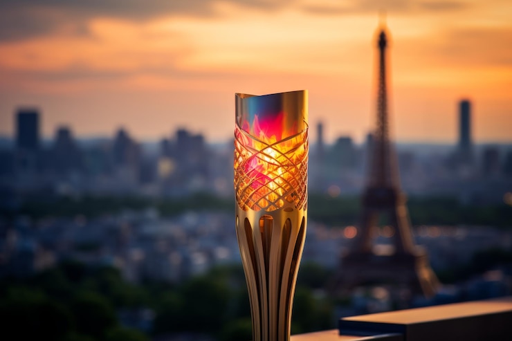 Photo vue rapprochée de la torche olympique en flammes avec l'horizon de paris en arrière-plan